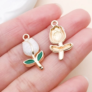 Vue détaillée de pendentifs tulipes DIY avec pétales blancs et feuilles vertes sur alliage