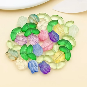 Macro shot of colorful glass tulip and leaf beads for handmade jewelry DIY projects