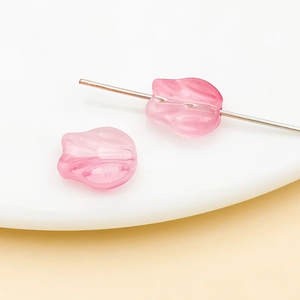 Detailed macro view of pink tulip-shaped glass beads with central hole for DIY jewelry making