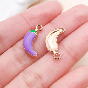 Macro detail of purple enamel chili pepper pendants with rose gold metallic finish