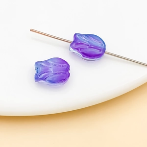 Macro shot of tulip-shaped glass beads in purple-blue gradient with center hole detail