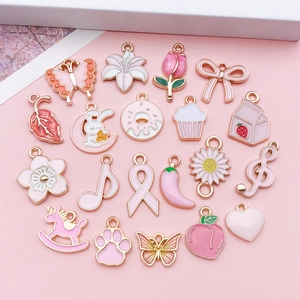 Flat lay of pink enamel charms set including bows donuts and flowers for DIY jewelry making