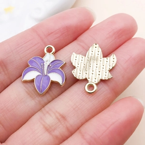 Macro detail of lily flower enamel pendant showing purple petals and golden metal back