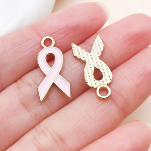 Detailed macro of pink ribbon charms with gold-plated alloy and smooth enamel finish