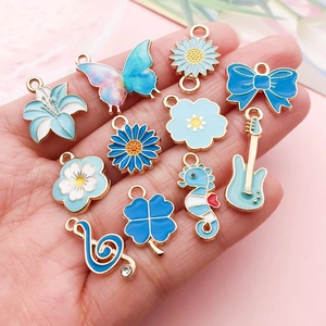 Handheld set of blue enamel charms including butterfly and clover for DIY jewelry