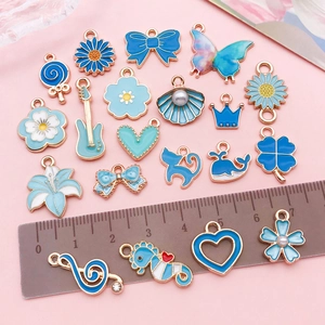 Assorted blue enamel pendants with gold edges featuring bow and clover designs