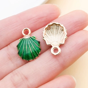 Macro detail of green enamel shell charms showing rose gold alloy texture and ring hook