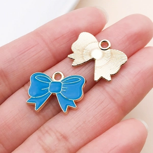 Macro view of blue enamel bow pendant with gold plating and textured backside