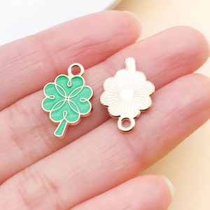 Detail of green enamel four leaf clover charms with gold metal finish and dual loops