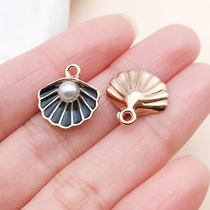 Détail macro de pendentifs coquillages en or rose avec émail noir et perle pour bijoux DIY