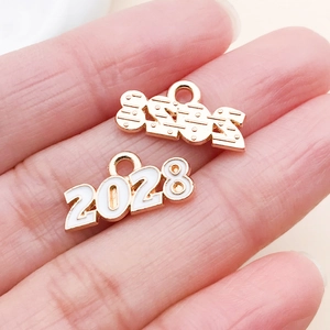 Makroaufnahme der Jahr 2028 Legierungsanhänger in Gold und Emaille für DIY-Schmuck