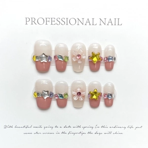 Handmade press-on nails with pink base, 3D stars, floral accents, and colorful rhinestones