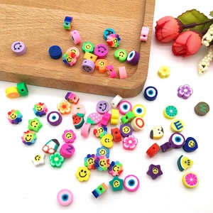 Vue détaillée de perles en pâte polymère colorées avec motifs de fruits et visages souriants
