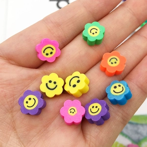 Gros plan de perles colorées en pâte polymère en forme de fleur avec visage souriant