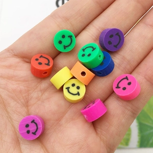 Gros plan de perles souriantes colorées en pâte polymère pour la création de bijoux