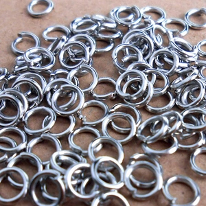 Macro view of scattered silver metal open jump rings for DIY jewelry making