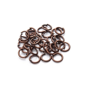 Macro shot of antique bronze jump rings for DIY jewelry making on white background