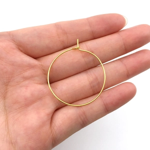 Detailed view of 30mm gold DIY earring hoop connector being held for scale