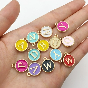 Close-up of colorful enamel letter charms with gold plating for DIY jewelry making