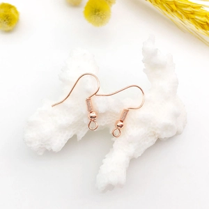 Close-up of rose gold earring hooks for DIY jewelry making with elegant floral decor