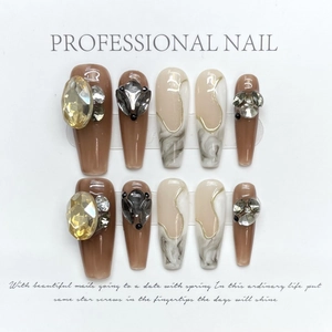 Handmade press-on nails with brown marble patterns and sparkling gemstone decorations