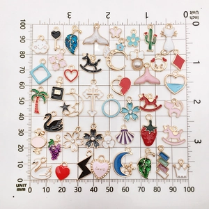 Mix of 100 colorful enamel alloy charms with animals and stars on a measurement grid