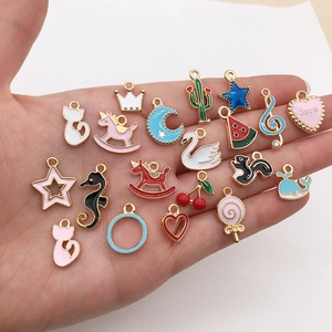 Detailed close-up of mixed alloy enamel charms including cats stars and hearts in palm