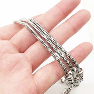 Detailaufnahme von drei flexiblen Schlangenketten in Silber mit hochdichter Schuppentextur