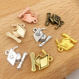 Détail de pendentifs chapeau de diplômé en or, argent et bronze pour la création de bijoux