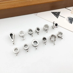 Detailed macro view of 13 silver alloy pendant connectors and beads for DIY jewelry making