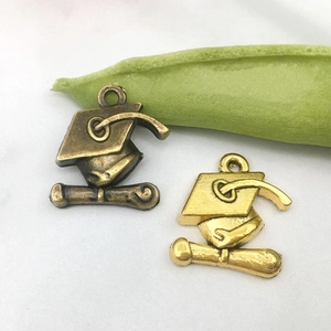 Détail de breloques chapeau de diplômé et diplôme en alliage bronze antique et doré