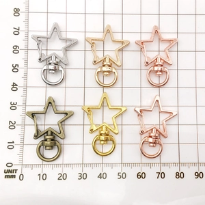 Stermvormige karabijnsluitingen in diverse kleuren op een millimeter meetrooster