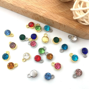 Vue détaillée de pendentifs ronds en strass colorés dorés et argentés pour bijoux artisanaux