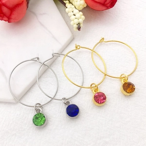 Détail macro de boucles d'oreilles zodiaque dorées et argentées avec cristaux colorés