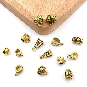 Macro detail of antique gold alloy bails and connectors with intricate floral carvings