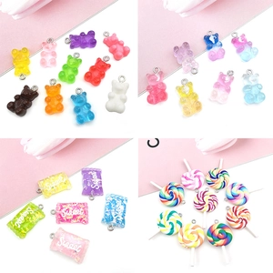Detail view of assorted resin candy pendants, glitter bears and lollipops for DIY crafts