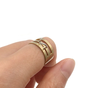 Close-up of modern hollow geometric ring in brass gold finish worn on finger