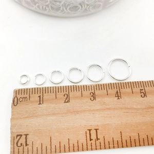Size comparison of silver jump rings from 3mm to 10mm next to a wooden ruler