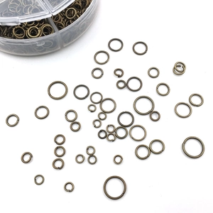 Detailed view of assorted bronze jump rings for jewelry making with plastic storage box