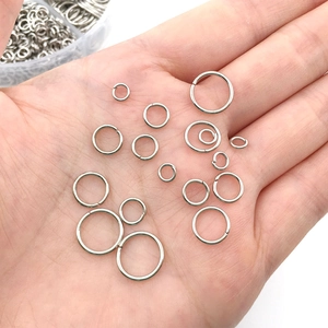 Detail shot of various sized silver jump rings held in hand for DIY jewelry making