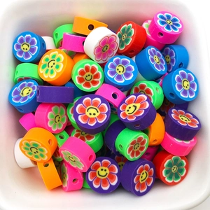 Détail macro de perles fleurs souriantes colorées en pâte polymère pour bijoux DIY