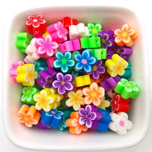 Détail macro de perles fleurs colorées de 10mm dans une coupelle en céramique