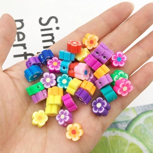 Gros plan de perles fleurs colorées en pâte polymère pour bijoux DIY dans la main