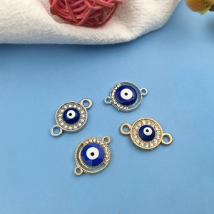 Makroansicht blauer Evil Eye Anhänger mit Straßsteinen in Gold- und Silberoptik