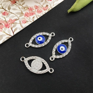Makro-Detail von silbernen Evil Eye Charms mit blauer Emaille und funkelnden Strass