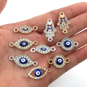 Makroaufnahme von Evil Eye und Hamsa Hand Anhängern für DIY-Schmuck in der Hand