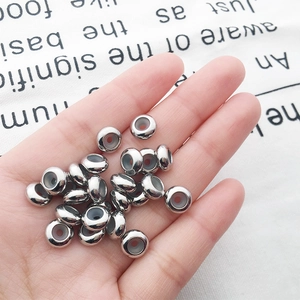 Silver copper spacer beads held in palm showing scale for DIY jewelry making