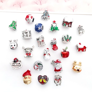 Détail de breloques de Noël en émail avec des motifs de renne et de bonhomme de neige