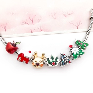 Vue macro du bracelet de Noël avec des breloques émaillées de rennes et de flocons