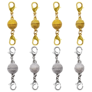 Macro shot of magnetic jewelry clasps with textured beads and lobster claws in gold and silver